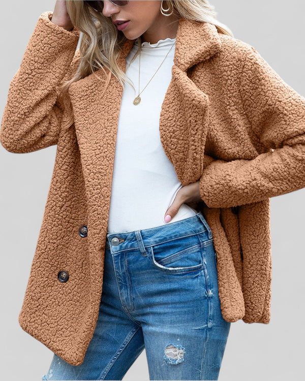 Vrouw in bruine teddyjas, witte top en blauwe jeans. Modieuze herfstkleding, casual stijl, warme jas, trendy damesmode.