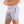 Man in grijze sportshorts met trekkoorden en zakken, merklogo zichtbaar. Ideaal voor fitness en hardlopen. Comfortabele en stijlvolle sportkleding.