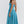 Vrouw in elegante blauwe midi-jurk met spaghettibandjes, perfecte zomeroutfit. Modieuze dameskleding, casual en stijlvol design.