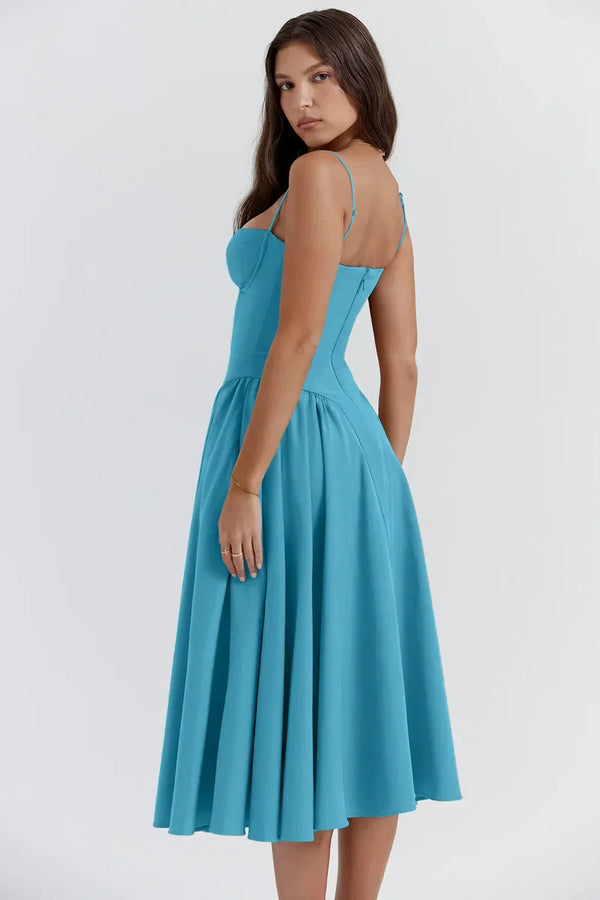 Vrouw in elegante blauwe midi-jurk met spaghettibandjes, perfecte zomeroutfit. Modieuze dameskleding, casual en stijlvol design.
