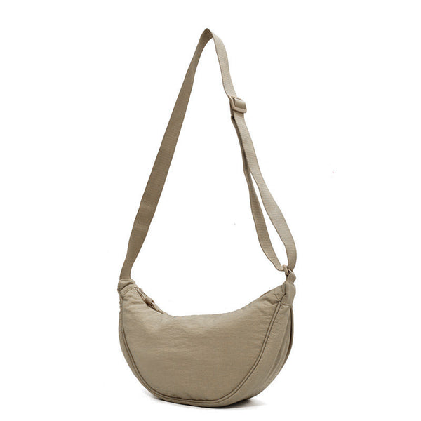 Beige schoudertas met verstelbare riem, halvemaanvormig ontwerp. Ideaal voor dagelijks gebruik. Trendy en functionele damesaccessoire.