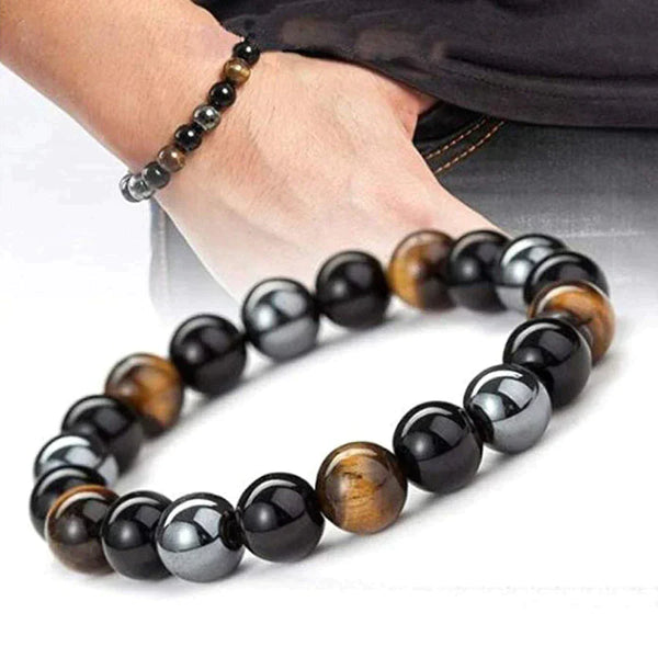 Armband met zwarte, zilveren en tijgeroog kralen, gedragen om een pols. Stijlvolle herenaccessoire, perfect voor mode en sieradenliefhebbers.