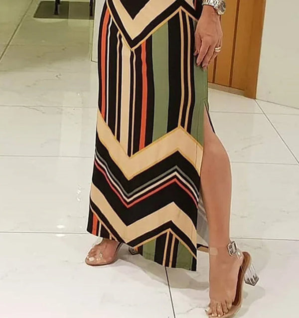 Vrouw in kleurrijke, gestreepte maxi-jurk met geometrisch patroon en sandalen. Modieuze dameskleding, zomeroutfit, trendy stijl.