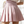Vrouw in roze geplooide rok en witte blouse met hartjespatroon, modieuze dameskleding, trendy zomeroutfit, stijlvolle casual look.