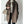 Bruine wollen jas met knopen, gedragen over een grijze coltrui. Vrouw houdt een stijlvolle beige handtas vast. Modieuze herfst- of winterkleding.