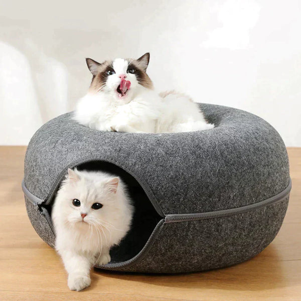 Twee katten in een grijze, ronde kattenmand met opening, op houten vloer. Ideaal voor huisdieren, comfortabel en stijlvol kattenbed.