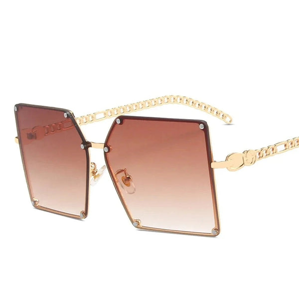 Gouden oversized zonnebril met rechthoekige glazen en kettingpootjes, modieuze damesaccessoire, UV-bescherming, trendy design.