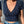 Vrouw in blauwe bloemen crop top en jeans met knopen, draagt een doorzichtige kralentas en gouden ketting. Zomermode, casual outfit.
