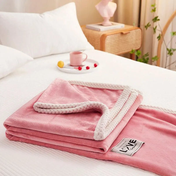 Roze fleece deken met witte rand op bed, luxe label zichtbaar. Perfect voor slaapkamerdecoratie, comfort en warmte. Ideaal voor moderne interieurs.
