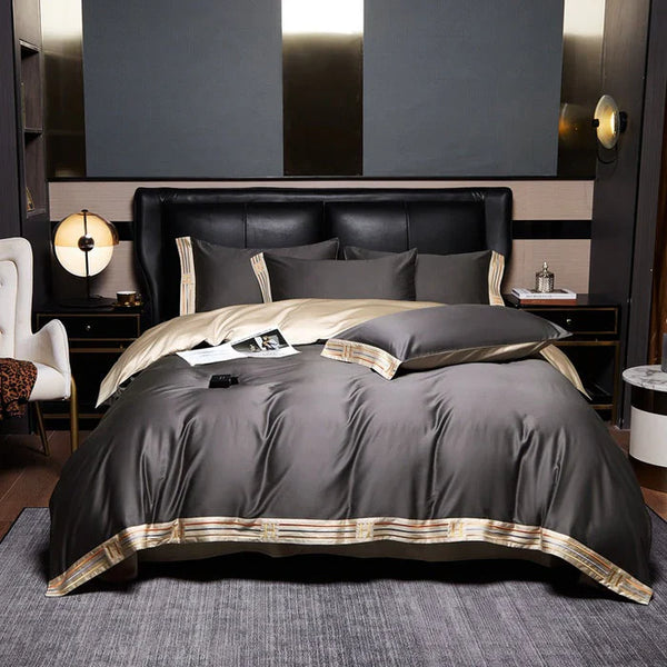 Luxe slaapkamer met zwart leren hoofdbord, grijze en gouden dekbedovertrekset, moderne nachtkastjes en sfeerverlichting.