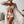 Vrouw in kleurrijke strandoutfit met abstract patroon, bestaande uit bikini, shorts en kimono. Zomerse mode, trendy strandkleding, stijlvolle hoed.