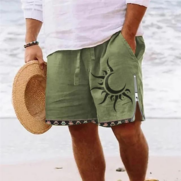 Man in witte blouse en groene korte broek met zonontwerp, strandachtergrond, strohoed in hand. Zomermode, strandkleding, casual herenkleding.
