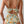 Vrouw in bloemenbadpak met ruches, rugsluiting en oranje bloemenprint. Trendy damesmode, zomerstrandkleding, stijlvolle badmode.