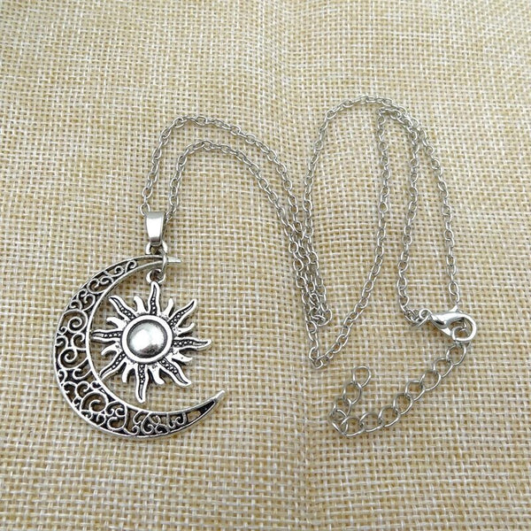 Zilveren ketting met zon en maan hanger op jute achtergrond, sieraden, bohemian stijl, vintage design, handgemaakt, cadeau voor vrouwen.