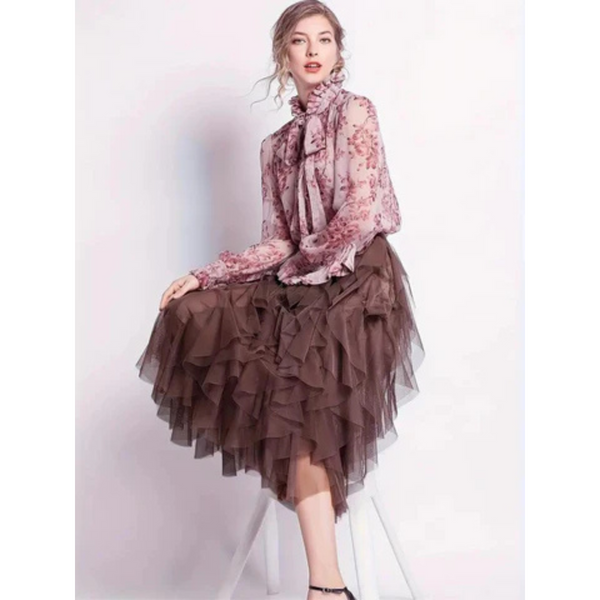 Elegante vrouw in roze kanten blouse en bruine tule rok, zittend op een witte stoel. Mode, dameskleding, stijlvolle outfit, trendy look.