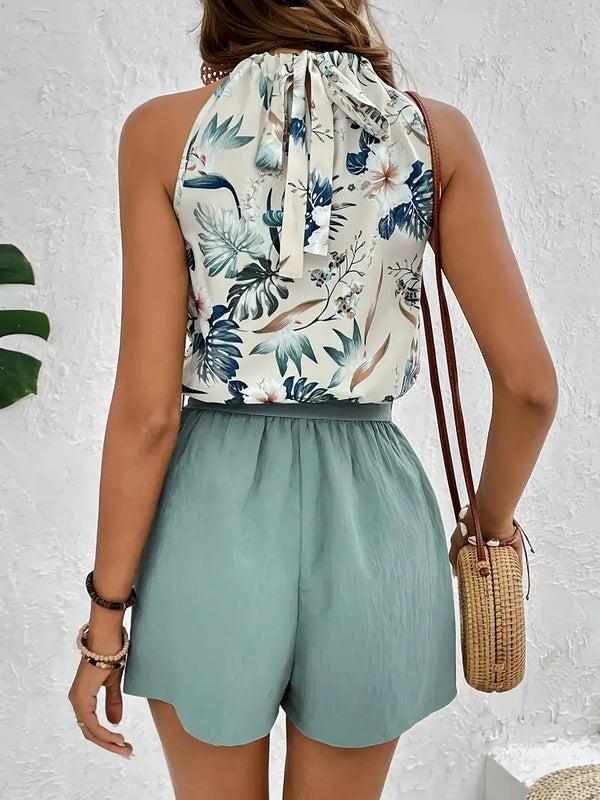Vrouw in zomerse outfit met bloemen top en groene shorts, draagt een rieten tas. Perfecte look voor strandvakantie of casual zomeruitjes.