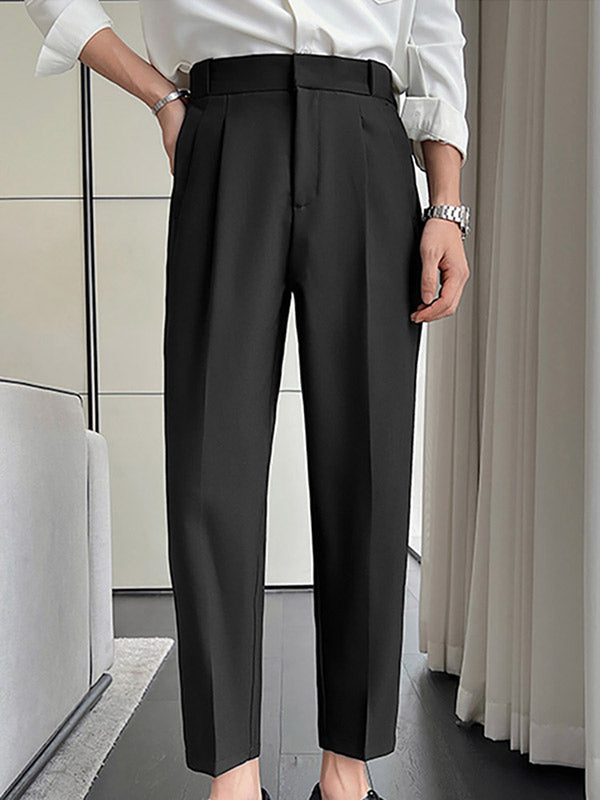 Zwarte herenbroek met hoge taille en plooien, gedragen met witte blouse. Stijlvolle zakelijke outfit, geschikt voor formele gelegenheden.