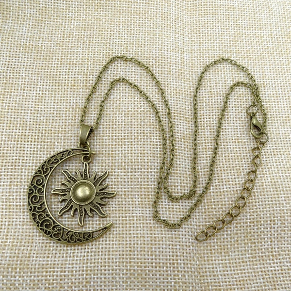 Antieke bronzen ketting met zon en maan hanger op jute achtergrond. Vintage sieraden, boho stijl, zon en maan symbool, unieke ketting.