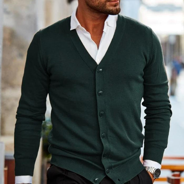 Donkergroene heren cardigan met V-hals en knopen, gedragen over een witte overhemd. Stijlvolle herenkleding, perfect voor casual en zakelijke looks.