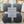 Grijze fleece deken op rotan stoel, Home Collection, zacht en warm, ideaal voor woonkamer of slaapkamer, luxe interieuraccessoire.
