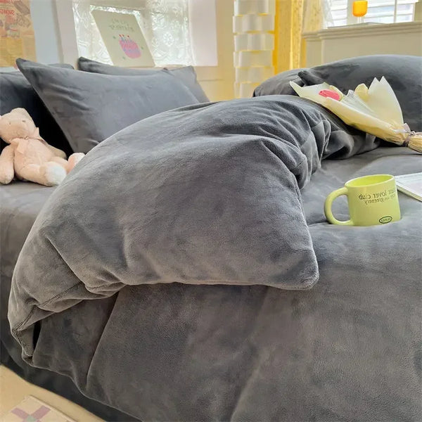 Grijze fluwelen dekbedovertrek op bed met teddybeer, bloemenboeket en groene mok. Luxe slaapkamerinrichting, comfortabel en stijlvol beddengoed.