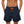 Donkerblauwe zwembroek met oranje trekkoord, gedragen door een man. Perfect voor strandmode en zomerse activiteiten. Comfortabel en stijlvol ontwerp.