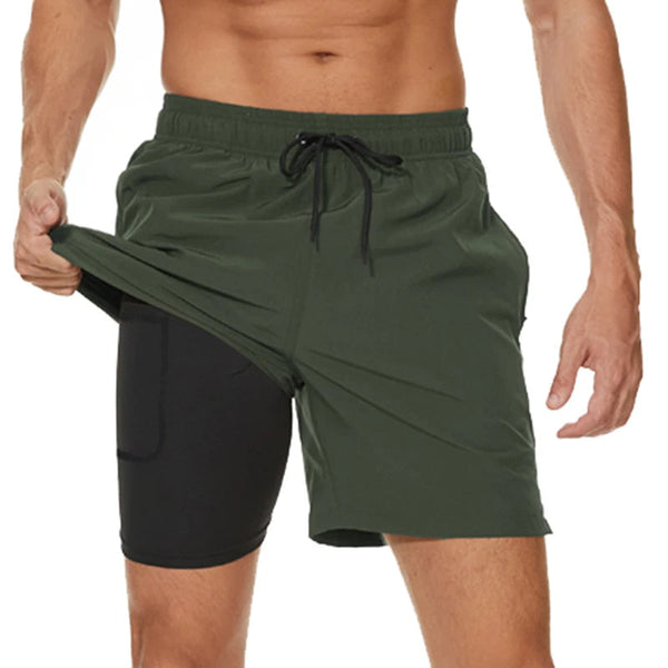 Groene sportshorts voor heren met zwarte compressielaag, verstelbare tailleband en zakken. Ideaal voor fitness en hardlopen.
