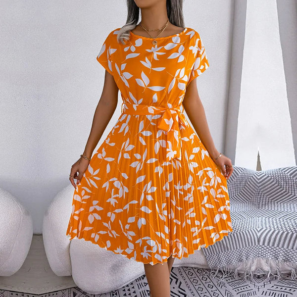Oranje zomerjurk met witte bloemenprint, korte mouwen en geplooide rok. Perfect voor casual en elegante zomerse outfits. Vrouwelijke mode.