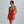 Vrouw in rode cocktailjurk met spaghettibandjes, elegante uitstraling, minimalistische achtergrond. Perfect voor avondkleding en mode-inspiratie.