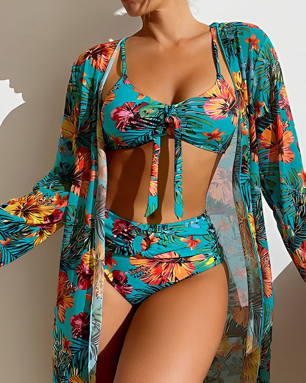 Vrouw in kleurrijke bloemenbikini en kimono, tropisch ontwerp, strandkleding, zomermode, hoge taille, blauw met oranje en gele bloemen.