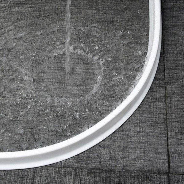 Ronde douchebak met waterstraal, grijze tegelvloer, moderne badkamer, waterafvoer, minimalistisch design, hoogwaardige materialen.