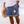 Man in blauwe zwembroek met Azteeks patroon en strohoed op strand. Zomerse strandmode, heren zwemkleding, casual strandoutfit.