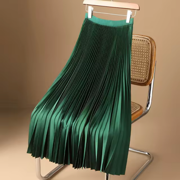 Groene geplooide rok op houten stoel, elegante damesmode, stijlvolle kleding, trendy plissérok, modieuze outfit, interieurinspiratie.