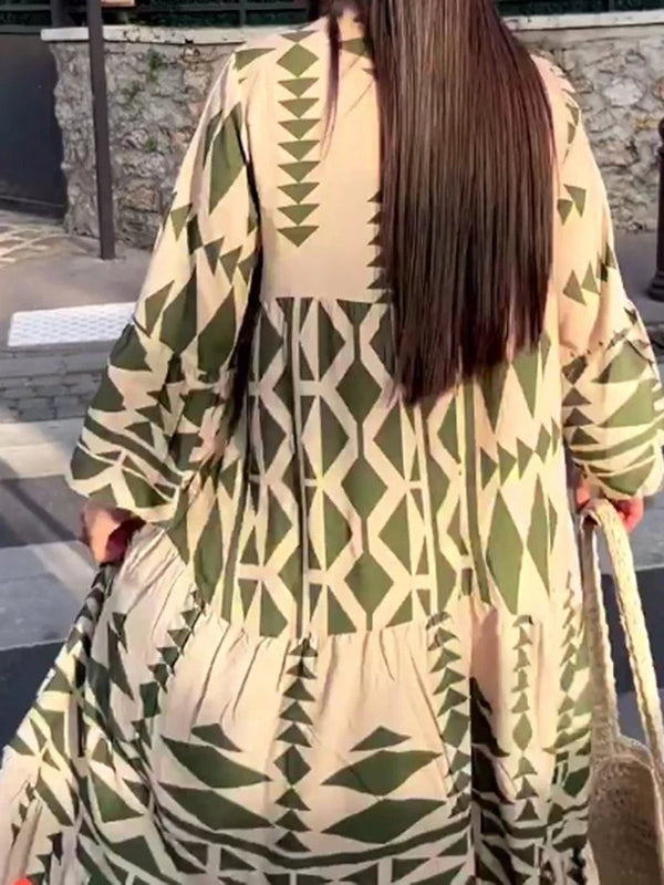 Lange jurk met geometrisch groen-wit patroon, gedragen door vrouw met lang haar, buiten op straat. Boho-stijl, modieuze dameskleding.
