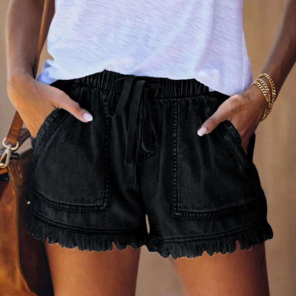 Zwarte denim shorts met elastische tailleband en zakken, gedragen door een vrouw in een wit T-shirt. Perfect voor casual zomeroutfits.