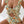 Vrouw in bloemenbadpak met ruffles en uitsnijding, zittend op bed. Trendy damesmode, zomerse strandkleding, stijlvolle badmode.