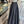 Vrouw in lange, zwarte plooirok bij houten toonbank in café. Stijlvolle mode, casual outfit, trendy rok, moderne kleding, winkelinterieur.