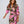Stijlvolle vrouw in roze en bruine jurk met barokprint, lange mouwen en knoopdetail, modetrend 2023, elegante dameskleding.