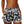 Vrouw draagt zwarte sportshort met witte bloemenprint, elastische tailleband en trekkoord. Perfect voor zomerse activiteiten en strandmode.