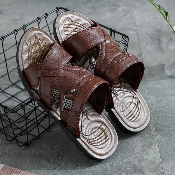 Bruine leren sandalen met kruisbanden op metalen rooster, stijlvolle herenslippers, comfortabele zool, geschikt voor casual zomeroutfits.