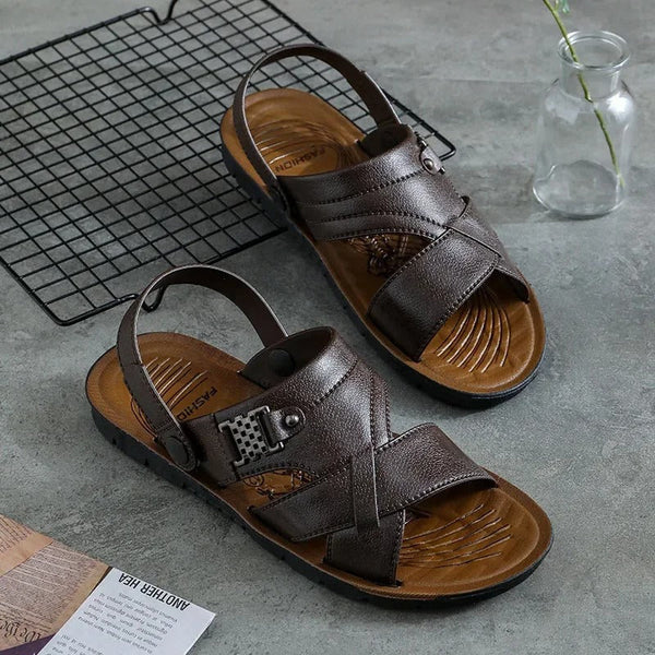 Bruine leren sandalen voor heren op grijze achtergrond, met verstelbare bandjes en antislipzool. Perfect voor casual zomeroutfits.