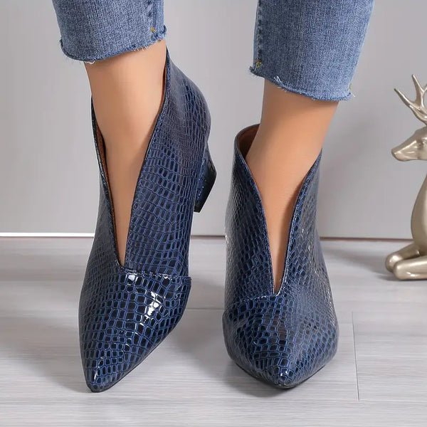 Blauwe enkellaarsjes met slangenprint, puntige neus en lage hak, gedragen met jeans. Modieuze dameslaarzen, trendy schoenen, herfstmode.