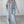 Grijze gebreide dames lounge set, bestaande uit een crop top, vest en wijde broek. Comfortabele en stijlvolle loungewear voor thuis.