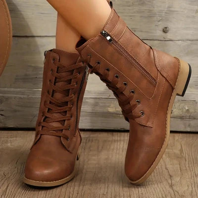 Bruine leren dameslaarzen met veters en rits, casual en stijlvol, perfect voor herfstmode. Comfortabele enkellaarzen op houten vloer.