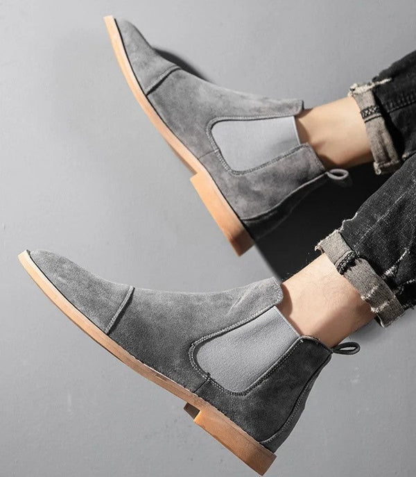Grijze suède Chelsea boots voor heren met elastische zijkanten en houten zool, gedragen met opgerolde jeans. Stijlvolle herenschoenen.