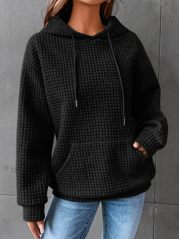 Zwarte gewatteerde hoodie voor dames, casual stijl, met capuchon en buidelzak, gecombineerd met blauwe jeans. Comfortabele en modieuze kleding.