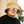 Man met beige teddy bucket hat en spiegelzonnebril, casual zwarte T-shirt. Stijlvolle herenkleding, trendy accessoires, mode voor mannen.