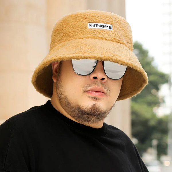 Man met beige teddy bucket hat en spiegelzonnebril, casual zwarte T-shirt. Stijlvolle herenkleding, trendy accessoires, mode voor mannen.
