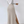 Vrouw in witte top en beige geribbelde maxi-rok met split, draagt witte sneakers. Modieuze dameskleding, minimalistische stijl.