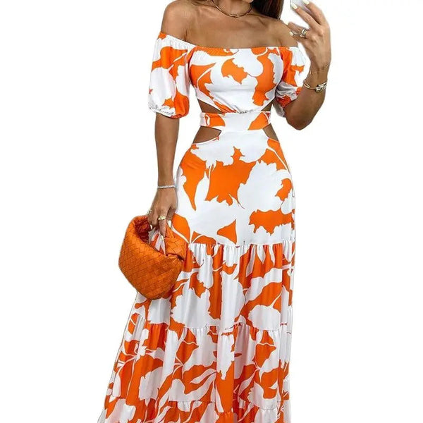 Vrouw in oranje-witte off-shoulder maxi-jurk met bloemenprint, draagt een oranje handtas. Zomerse mode, elegante dameskleding.